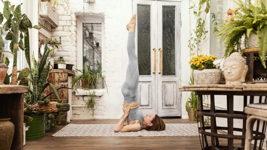 mulher praticando yoga 1024x576 - 🧘&zwj;♀️ Descubra os Tipos de Yoga e Transforme Sua Vida com a Pr&aacute;tica Ideal